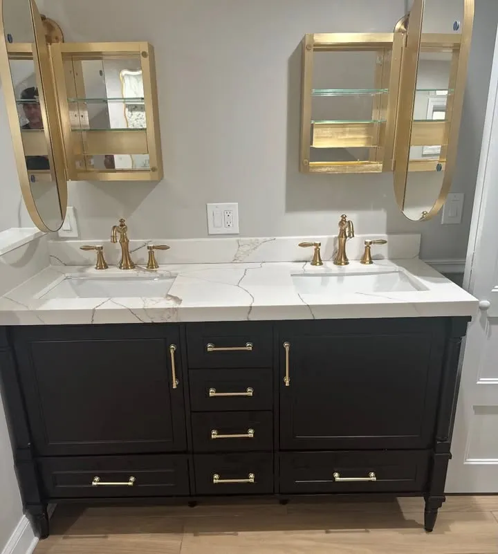 Black double vanity with gold fixtures and marble top